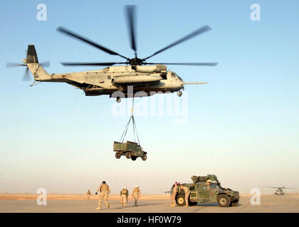 A US Marine Corps (USMC) CH-53E Super Stallion, 2nd Marine Aircraft Wing (MAW), lifts a flank armored High-Mobility Multipurpose Wheeled Vehicle (HMMWV) from the flightline of Al Asad Air Base (AB), Iraq, for delivery to infantry units inserted at a forward location for Operation RIVER SWEEP in support of Operation IRAQI FREEDOM. Marine CH-53E Super Stallion (2164964162) Stock Photo