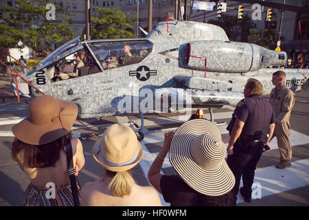 Sgt. Dennis Lally, a Cleveland policeman, and other locals watch as an AH-1W Super Cobra helicopter with Marine Helicopter Light Attack Squadron 773, based out of Belle Chasse, La., is towed along West Superior Avenue June 10, 2012. The aircraft was escorted by HMLA-773 Marines to Public Square where it will be on display. The square is one of the static displays positioned by Marines for the Marine Week Cleveland. Other displays open to the public will be located at Voinovich Park, Gateway Plaza and the Rock and Roll Hall of Fame. The Marine Week Cleveland runs June 11-17 and celebrates the c Stock Photo