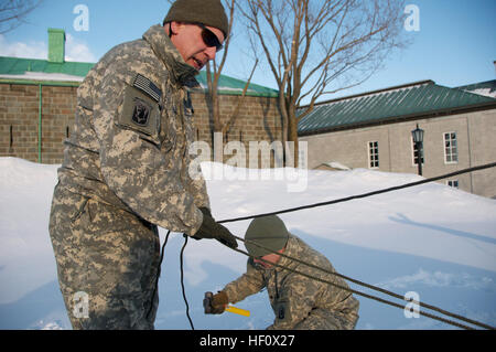 Staff Sgt. Steve Jennings, a Soldier from the Army Mountain Warfare School disassembles a tent at Canadian Forces Base Valcartier in preparation for the trip to Baffin Island, March 1, 2014. These Soldiers will train with Canadian Forces in the Arctic Cirlce as part of Guerrier Noridque. (U.S. Army National Guard photo by Staff Sgt. Jason Alvarez) Guerrier Nordique 2014 140301-Z-AC359-309 Stock Photo