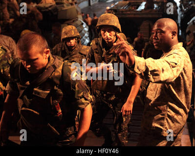 U.S. Marine Corps Cpl. Steven Christian with Security Cooperation Task Force Africa Partnership Station 2012 directs Romanians from the 307th Naval Infantry aboard the USS Fort McHenry, Aug. 12, 2012. The Romanians stayed aboard the USS Fort McHenry as part of Exercise Summer Storm 12. Summer Storm 120812-M-JU449-045 Stock Photo