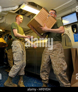 Lance Cpl. Aaron Waters, a Camdler, N.C., native and Lance Cpl. Michael Schineider, a Cleveland, Ohio, native, both with the 24th Marine Expeditionary Unit, work together carrying fresh fruits, vegetables and dry goods during a replenishment at sea detail aboard the USS Iwo Jima, Aug. 29, 2012. During the RAS the USS Iwo Jima took on fuel, food supplies and mail to sustain the ship through the next few weeks. The 24th MEU is deployed with the Iwo Jima Amphibious Ready Group as a theater reserve force for U.S. Central Command and is providing support for maritime security operations and theater Stock Photo