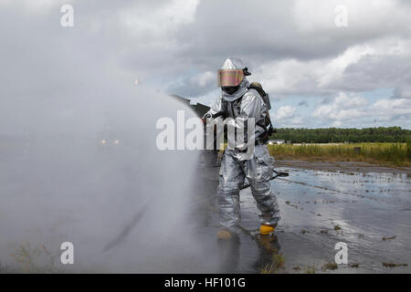 An aircraft rescue firefighter sprays down an AV-8B Harrier with jets of water to put out any last remnants of a fire during a training exercise at Marine Corps Auxiliary Landing Field Bogue, N.C., Sept. 14. The mission of aircraft rescue firefighters is to save lives and property. Sgt. Keith Molinary, the training chief of the Marine Wing Support Squadron 271 aircraft rescue firefighters, said it is useful to train alongside the rest of the squadron to get everyone on the same page. Workhorses refresh capabilities with field training 120914-M-AF823-027 Stock Photo