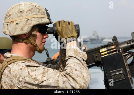 Lance Cpl. Ryant Williams, a native of Rome, Ga., and machine gunner with Weapons Company, Battalion Landing Team 1st Battalion, 2nd Marine Regiment, 24th Marine Expeditionary Unit, looks through binoculars aboard the USS New York to observe his surroundings as the ship transits through the Suez Canal off the coast of Egypt, Nov. 5, 2012. The 24th MEU is deployed with the Iwo Jima Amphibious Ready Group and is currently in the 6th Fleet Area of Responsibility as a disaster relief and crisis response force. Since deploying in March, they have supported a variety of missions in the U.S. Central  Stock Photo