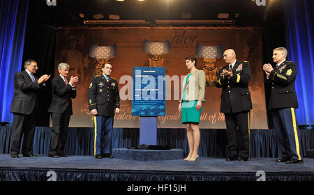 Former U.S. Army Staff Sgt. Clinton L. Romesha, third from left, and his wife, Tammy, third from right, receive applause from Secretary of Defense Leon E. Panetta, left; Secretary of the Army John McHugh, second from left; Chief of Staff of the Army Gen. Raymond T. Odierno, second from right; and Sgt. Maj. of the Army Raymond F. Chandler III, right, during a ceremony at the Pentagon in Arlington, Va., Feb. 12, 2013. A day earlier, Romesha received the Medal of Honor during a ceremony at the White House in Washington, D.C., for his actions during the Battle of Kamdesh at Combat Outpost Keating  Stock Photo