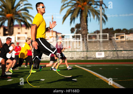 Marine veteran Sgt. Gabriel Martinez, 24-year-old native of Golden, Colo., performs dynamic warm-up exercises during track practice for the 2013 Marine Corps Trials at Marine Corps Base Camp Pendleton, Calif., March 1, 2013. While attached to 1st Combat Engineer Battalion, Martinez lost one leg above the knee and the other below the knee in an improvised explosive device blast in Afghanistan on Thanksgiving Day in 2010. He has since gained proficiency with his prosthetic running blades and plans to compete in the pentathlon at the Trials, which includes track and field, swimming, cycling, arch Stock Photo