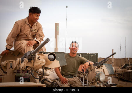 U.S. Marine Corps Lance Cpl. Phillip Lim, left, and Cpl. Brandon Baber, both assigned to Delta Company, 1st Tank Battalion, Regimental Combat Team 7, take a break while conducting function checks on an M1A1 Abrams tank at Camp Shir Ghazay, Helmand province, Afghanistan, April 25, 2013. (DoD photo by Staff Sgt. Ezekiel R. Kitandwe, U.S. Marine Corps/Released) 130425-M-RO295-102 (8692290195) Stock Photo