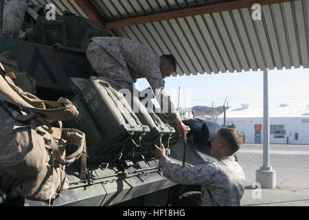 Left to right, U.S. Marine Corps Cpl. Leonardo Saldivar, a Light Armored Vehicle (LAV) crewman, and Lance Cpl. Patrick Anger, an LAV driver, both with Apache Company, 3rd Light Armored Reconnaissance Battalion, secure water cans to the side of an LAV 25 during Exercise DESERT SCIMITAR aboard Marine Corps Air Ground Combat Center Twentynine Palms, Calif., April 28, 2013. Exercise DESERT SCIMITAR was conducted to allow 1st Marine Division to sustain their ability to plan and execute command and control functions in both offensive and defensive scenarios. (Official US Marine Corps photo by Sgt. M Stock Photo