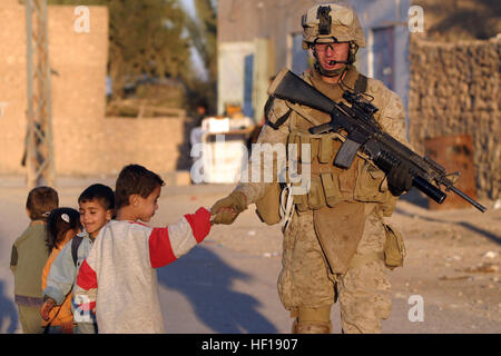 061219-M-9019H-065 Haqlaniyah, Al Anbar, Iraq (Dec. 18, 2006) Ð Lance Cpl. Jacob E. Nation from Elizabethtown, Ill., assigned to the 2nd Battalion, 3rd Marines (2/3) greets Iraqi children as he patrols through the city of Haqlaniyah, Iraq during Maritime Security Operations (MSO) to develop the Iraqi Security Forces. 2/3 is deployed with Regimental Combat Team 7, I Marine Expeditionary Force (FWD) in support of the ongoing rotation of forward-deployed forces. U.S. Marine Corps photo by Sgt. Brian M. Henner (RELEASED) US Navy 061219-M-9019H-065 Lance Cpl. Jacob E. Nation from Elizabethtown, Ill Stock Photo