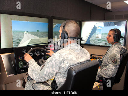 Pvt. Anthony Abila, left, and Pfc. Daniel Rendon, both combat engineers with the 454th Engineer Company, 111th Engineer Battalion, Texas Army National Guard, work together during a computerized, simulated patrol in the Multipurpose Clearance Vehicle (MPVC) Buffalo trailer at Camp Bowie in Brownwood, Texas, June 17, 2013.  The Virtual Clearance Training Suite (VCTS) helps familiarize Service members with the different mine-resistant, ambush-protected (MRAP) vehicles to used to identify and react to roadside bombs. (National Guard photo by Laura L. Lopez/Released) Texas National Guard engineers  Stock Photo