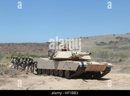 Canadian soldiers serving with 2nd Battalion, Royal 22nd Regiment, move into an urban training course behind the cover of a M1A1 Abrams tank during Exercise Dawn Blitz here, June 21, 2013. Canadian soldiers coordinated movements with Marines from 1st Tank Battalion to clear the mock village of enemy role players. Dawn Blitz 2013 is a multinational amphibious exercise that promotes interoperability between the Navy and Marine Corps and coalition partners, June 11-28. Participating countries include Canada, Japan, New Zealand and military observers from seven countries. (U.S. Marine Corps photo  Stock Photo