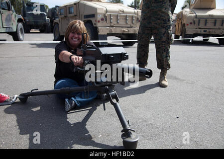 Janet Fliegel, wife of U.S. Marine Corps Sgt. Maj. Daniel Fliegel, Sgt. Maj. of Headquarters Battalion (HQBN), 1st Marine Division (1st MARDIV) poses with a MK 19 40 mm grenade machine gun during HQBN's Jane Wayne day aboard Camp Pendleton, Calif. June 22, 2013. Jane Wayne Day is an opportunity for family and friends of service members to participate in Marine Corps training, while strengthening family readiness through team building. (U.S. Marine Corps photo by Pfc. Adrianna Stalker, 1st Marine Division/Released) GI Joe and Jane Day Challenge 130622-M-HY842-093 Stock Photo