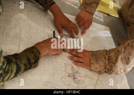 Afghan National Army soldiers plot targets on a map during the forward observer class of the Regional Corps Battle School D-30 artillery course at the camp's Regional Military Training Center, June 25. The artillery course, which also includes gun line and fire direction center training, is a recent addition to the RCBS at the ANA leadership's request. Twenty-six soldiers from all four brigades within the ANA's 215th Corps travelled to Camp Shorabak for the course. (U.S. Marine Corps Photo by Sgt. Bryan Peterson/Released) Regional Corps Battle School now teaching artillery 130625-M-TM093-088 Stock Photo