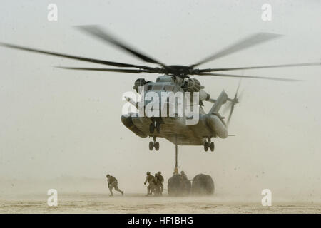 U.S. Marines with Combat Logistics Battalion 2 secure 1,500 pounds of fuel to a cable under a CH-53E Super Stallion helicopter at Al Anbar province, Iraq, April 14, 2007.  CLB-2 and Marine Heavy Helicopter Squadron 465 are aiding in supplying Marines from 1st Battalion, 2nd Marine Regiment, as they construct a combat outpost in Baghdad.  (U.S. Marine Corps photo by Sgt. James R. Richardson) (Released) Marine CH-53E Super Stallion (2164931812) Stock Photo