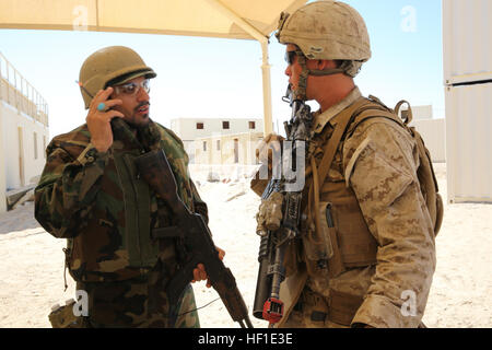 MARINE CORPS AIR GROUND COMBAT CENTER TWENTYNINE PALMS, Calif. – Lance Cpl. Jared Edwards (right), a team leader, 3rd Battalion, 7th Marine Regiment, talks to a role-player acting as an Afghan National Army soldier while conducting a mock raid during the Integrated Training Exercise here, Aug. 12, 2013. Edwards, 21, a native of Arvada, Colo., speaks Pashtu, which enables him to communicate with the role-players. The Marines assume a supporting role while deployed to Afghanistan by letting the ANA and the Afghan National Police lead in combat operations. The ITX is a training exercise held to p Stock Photo