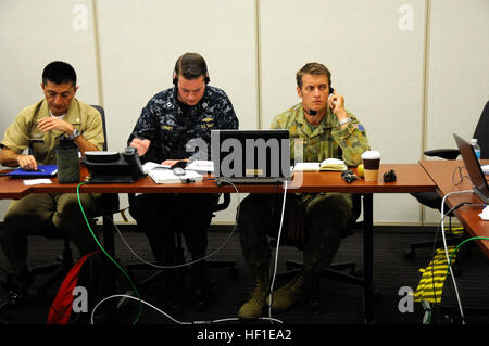 Australian Army Maj. Benjamin Watson, the assistant operations officer from the U.S. Marine Corps 15th Marine Expeditionary Unit, listens, through interpreter services, to an fellow PANAMAX 2013 participant during a discussion about defense strategies, August 15. Watson is participating in PANAMAX as a member of the Coalition Forces Maritime Component Command Cell. PANAMAX 2013 is an annual U.S. Southern Command-sponsored exercise series that focuses on ensuring the defense of the Panama Canal. PANAMAX 2013 develops and sustains relationships that improve the capacity of our emerging and endur Stock Photo