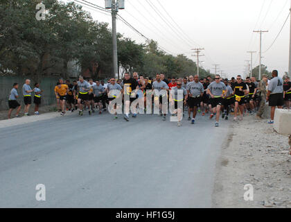 Participants in  the Army Ten-Miler shadow run begin running from the starting line at Bagram Air Field, Afghanistan, Sept. 22, 2013. More than 700 U.S. and coalition force service members and civilians representing eight different countries gathered in the early morning to participate in a shadow run for the 29th Annual Army Ten-Miler hosted by 101st Airborne Division (Air Assault). (Photo by U.S. Army National Guard Sgt. Anita VanderMolen, 129th Mobile Public Affairs Detachment/Released) Army Ten-Miler shadow run held at Bagram Air Field 130922-Z-NT154-042 Stock Photo