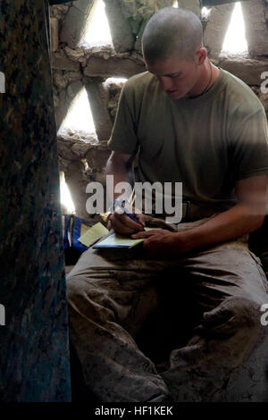 090909-M-7825S-012 HELMAND PROVINCE, Afghanistan (Sept. 9, 2009) Hospital Corpsman 3rd Class Landon Hoft, assigned to Bravo Company, 1st Battalion, 5th Marine Regiment, writes a letter to his family at forward operating base Blue Falcons Nest. 1st Battalion, 5th Marine Regiment is deployed with Regimental Combat Team 3, conducting counter insurgency operations with the Afghan national security forces in southern Afghanistan. (U.S. Marine Corps photo by Cpl. Artur Shvartsberg/Released) US Navy 090909-M-7825S-012 Hospital Corpsman 3rd Class Landon Hoft, assigned to Bravo Company, 1st Battalion,  Stock Photo