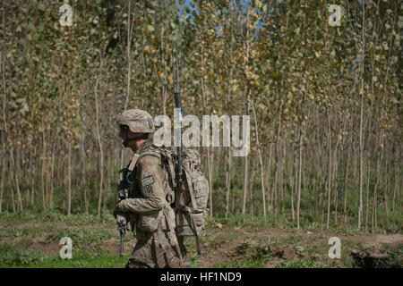 U.S. Army Spc. Christopher Mathies, of Columbia, Tenn., an infantryman with Troop C, 6th Squadron, 8th Cavalry Regiment 'Mustangs,' 4th Infantry Brigade Combat Team, 3rd Infantry Division, skirts a tree line during an afternoon foot patrol near Forward Operating Base Shank, Logar province, Afghanistan, Oct. 10, 2013. The purpose of the patrol, which took the team across rivers, over irrigation ditches and through freshly plowed fields and thickly wooded areas, was to meet with local Afghan citizens and deter enemy activity in the area. (U.S. Army National Guard photo by Sgt. Margaret Taylor, 1 Stock Photo