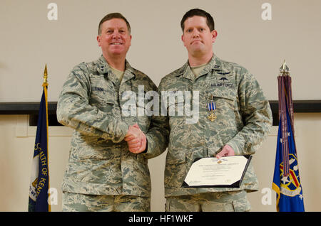 Kentucky's adjutant general, Maj. Gen. Edward W. Tonini, presents Capt. Nathan Tingle, a combat rescue officer in the 123rd Special Tactics Squadron, with the Distinguished Flying Cross during an award ceremony held Jan. 12, 2014, at the Kentucky Air National Guard Base in Louisville, Ky. Tingle earned the award for extraordinary achievement while conducting rescue operations in Afghanistan in 2011. (U.S. Air National Guard photo by Airman 1st Class Joshua Horton) Kentucky airmen honored for heroism and service in Afghanistan 140112-Z-DI861-099 Stock Photo