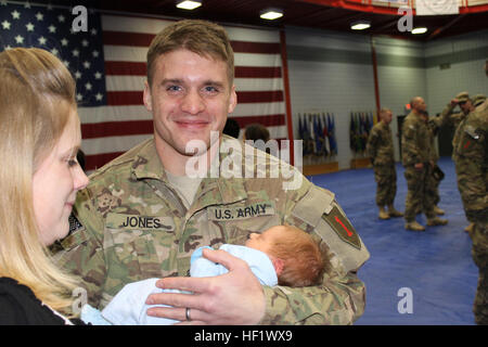 Sgt. Jesse Jones, a soldier assigned to the 2nd Battalion, 2nd Infantry Regiment, 3rd Infantry Brigade Combat Team, 1st Infantry Division, holds his son Thomas for the first time Jan 18, during a welcome home ceremony at Fort Knox's Physical Fitness Center. Thomas was only two days old. Jones and approximately 130 soldiers from the 3rd IBCT returned home from a nine-month deployment to Afghanistan. (U.S. Army Photo By: Sgt. Thomas Duval, 3rd IBCT Public Affairs) Fort Knox soldiers return home from nine-month deployment to Afghanistan (Image 4 of 4) (12091759064) Stock Photo