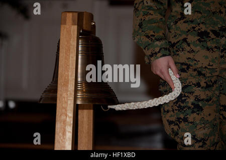 U.S. Navy Petty Officer 3rd Class Brooke Lopshire with 2nd Marine Division (2nd MarDiv) rings the bell during roll call of the 2nd MarDiv remembrance service on Camp Lejeune, N.C., Jan. 31, 2014.  The bell is rung at the end of each of the fallen Marines and Saliors watch from the Battle of Guadicanal to the present. (U.S. Marine Corps photo by Lance Cpl. David McKenzie, 2nd MARDIV Combat Camera/Released) SMDA 140131-M-HZ136-044 Stock Photo