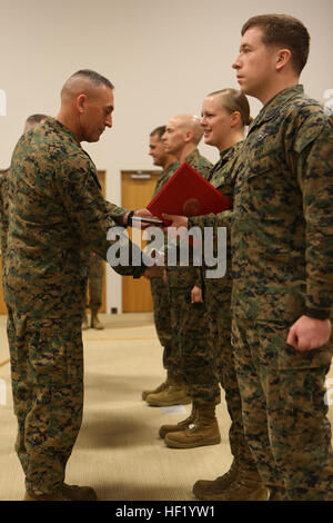 Brigadier Gen. James W. Lukeman, the 2nd Marine Division commanding general, congratulates Navy Petty Officer 3rd Class Brooke E. Lopshire, the religious program specialist with Headquarters Battalion, 2nd Marine Division, on her achievement as the Junior Sailor of The Quarter during the Morning Awards Ceremony aboard Marine Corps Base Camp Lejeune Feb. 27, 2014. The Junior Sailor of The Quarter Award is presented to sailors (E-4 through E-5) who perform their duties in a highly exemplary and professional matter. Marines, sailors awarded for outstanding performances 140227-M-BW898-010 Stock Photo