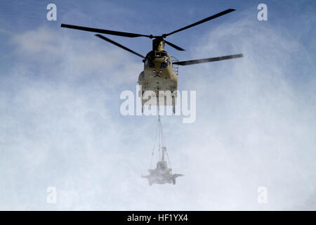 An M-177 155mm howitzer is transported by a CH-47 Chinook during cold weather sling load operations at Camp Grayling Joint Maneuver Training Center, Mich., Feb 28, 2014. (Michigan National Guard photo by Staff Sgt. Kimberly Bratic/Released) Michigan National Guard conducts cold weather sling load and howitzer live fire exercise 140228-Z-LE308-005 Stock Photo