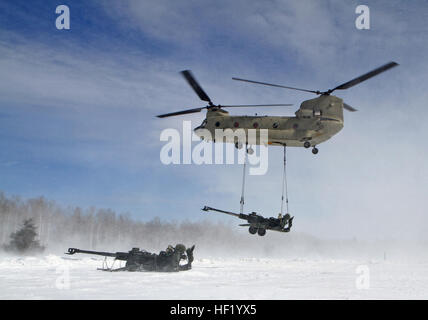 An M-177 155mm howitzer is transported by a CH-47 Chinook during cold weather sling load operations at Camp Grayling Joint Maneuver Training Center, Mich., Feb. 28, 2014. (Michigan National Guard photo by Staff Sgt. Kimberly Bratic/Released) Michigan National Guard conducts cold weather sling load and howitzer live fire exercise 140228-Z-LE308-003 Stock Photo