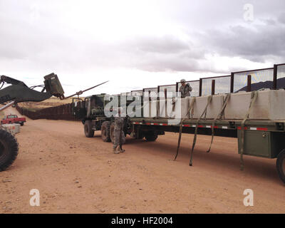 Staff Sgt. Joaquin Lopez (left) and Staff Sgt. Ruben Cruz, Arizona Army National Guard soldiers assigned to the 2220th Transportation Company in Tucson, offload concrete barriers in Naco near the Arizona-Mexico border, March 1. The soldiers partnered with U.S. Customs and Border Protection to deliver the barriers from El Centro, Calif., to shore up security measures while accomplishing some much-needed training for convoy operations. (U.S. Army National Guard photo by Army Capt. Janek Kaslikowski) Arizona soldiers, US CBP unite to secure border hot spot 140301-Z-ZZ000-001 Stock Photo