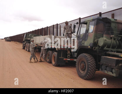 Arizona Army National Guard Soldiers assigned to the 2220th Transportation Company in Tucson, offload concrete barriers in Naco near the Arizona-Mexico border, March 1. The soldiers partnered with U.S. Customs and Border Protection to deliver the barriers from El Centro, Calif., to shore up security measures while accomplishing some much-needed training for convoy operations. (U.S. Army National Guard photo by Army Capt. Janek Kaslikowski) US CBP recognizes Arizona SoldiersE28099 contribution to border security 140301-Z-XX123-503 Stock Photo