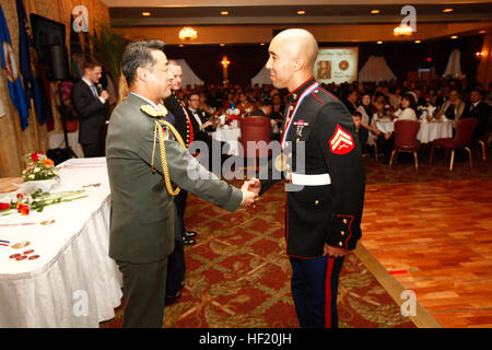 Japan Ground Self-Defense Force Maj. Gen. Shigeru Kobayashi, left, shakes hands with U.S. Marine Cpl. Michael S. Williamson during the 43rd annual USO Service Salute March 8 at the Butler Officers' Club on Camp Foster. Williamson was among seven Japan Self-Defense Force and U.S. service members recognized for volunteer efforts and community support. Kobayashi is the commanding general of the 15th Brigade, Western Army. Williamson is a field artillery radar operator with Headquarters Battery, 12th Marine Regiment, 3rd Marine Division, III Marine Expeditionary Force. USO awards JSDF, US service  Stock Photo