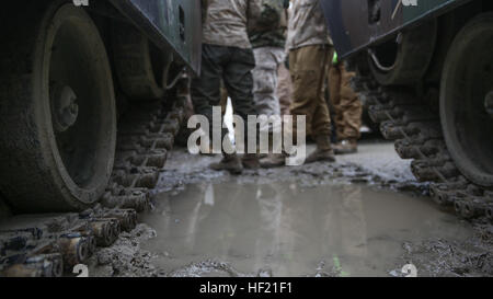 Two M1A1 Abrams Main Battle Tanks with 2nd Tank Battalion, 2nd Marine Division, wait in the mud before being loaded onto the railcar for transport to Fort Pickett, Va., from Marine Corps Base Camp Lejeune, N.C., March 18, 2014. Marines successfully loaded the tanks on the railcars despite the winds, rain and mud. The battalion is heading to Virginia for one month to complete field training. More than 350 Marines and sailors will be taking part in the training as well as a total of 22 tanks and four M88A2 Hercules Recovery Vehicles. 'Masters of the Iron Horse' load up for DFT 140318-M-BW898-002 Stock Photo