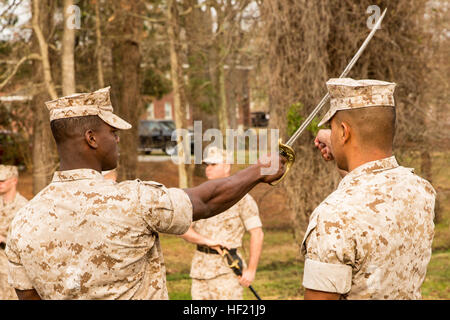 An instructor with the 2nd Marine Logistics Group's Corporal's Course assists a noncommissioned officer with sword drill movements aboard Camp Lejeune, N.C., March 20, 2014. Instructors used a combination of demonstration and repetitive application to hone the Marines' form and command presence. CorporalE28099s Course forges next generation of Marine NCOs 140320-M-IU187-014 Stock Photo