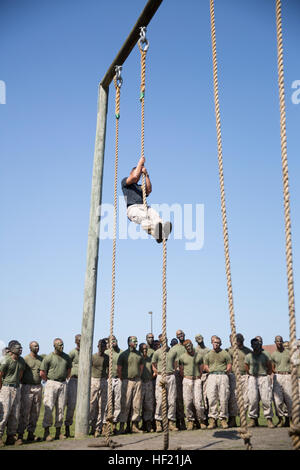 An instructor with 2nd Marine Logistics Group's Corporal's Course demonstrates rope climbing techniques at an obstacle course at Camp Lejeune, N.C., March 20, 2014. The Marines ran the obstacle course as part of their daily fitness regimen at the course. CorporalE28099s Course forges next generation of Marine NCOs 140320-M-IU189-007 Stock Photo