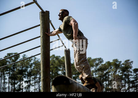 Cpl. Joshua Munro, a Troy, Mich., native and student at 2nd Marine Logistics Group's Corporal's Course, climbs atop an obstacle during one of the course's daily fitness sessions at Camp Lejeune, N.C., March 20, 2013. Munro, originally a machine gunner by trade, said the course offered him a lot of the formal leadership education he wasn't able to receive after completing his specialty training and deploying to Afghanistan. CorporalE28099s Course forges next generation of Marine NCOs 140320-M-IU189-010 Stock Photo