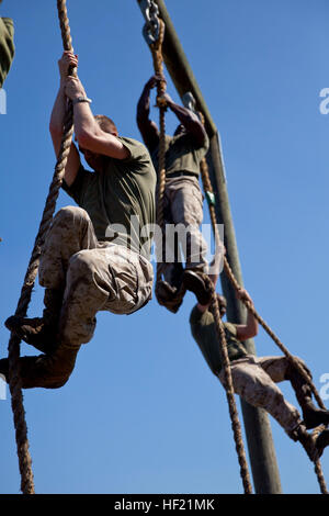 Marines attending 2nd Marine Logistics Group's Corporal's Course at Camp Lejeune, N.C., climb ropes at the end of an obstacle course March 20, 2014. Earlier in the day, the Marines conducted sword and guidon training as part of the courses multi-faceted curriculum. CorporalE28099s Course forges next generation of Marine NCOs 140320-M-ZB219-012 Stock Photo