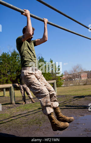 : A Marine attending 2nd Marine Logistics Group's Corporal's Course swings over a bar while completing an obstacle course challenge at Camp Lejeune, N.C., March 20, 2014. Instructors at the course paired hands-on physical training with daily classroom instruction to challenge their students throughout the course. CorporalE28099s Course forges next generation of Marine NCOs 140320-M-ZB219-015 Stock Photo