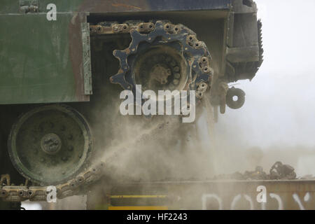 Dust and sand falls off the tracks of an M1A1 Abrams Main Battle Tank, with 2nd Tank Battalion, 2nd Marine Division, as the vehicle moves off a railcar at Fort Pickett, Va., March 28, 2014. More than 350 Marines and sailors with the battalion will be taking part in the month-long, field exercise. Twenty-two tanks and four M88A2 Hercules Recovery Vehicles were unloaded from the railcars. 'Masters of the Iron Horse' reach Ft. Pickett 140328-M-BW898-005 Stock Photo