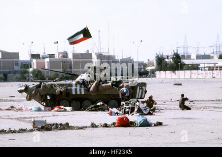 Kuwaiti soldiers sit beside an Iraqi BMP-2 mechanized infantry combat vehicle that was captured during Operation Desert Storm.  The vehicle has an AT-5 Spandrel anti-tank guided missile mounted atop its turret. Kuwaiti soldiers and a Kuwaiti BMP-2 Stock Photo