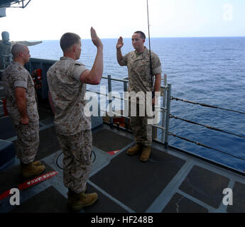 U.S. Marine Corps Sgt. Joshua Lamb, Battalion Landing Team 1st Battalion, 6th Marine Regiment, 22nd Marine Expeditionary Unit (MEU), motor transportation maintenance chief and native of Brick, N.J., repeats the oath of enlistment during his re-enlistment ceremony while fishing aboard the USS Bataan (LHD 5). The 22nd MEU is deployed with the Bataan Amphibious Ready Group as a theater reserve and crisis response force throughout U.S. Central Command and the U.S. 5th Fleet area of responsibility. (U.S. Marine Corps photo by Cpl. Caleb McDonald/Released) 22nd MEU Marine re-enlists while fishing at Stock Photo