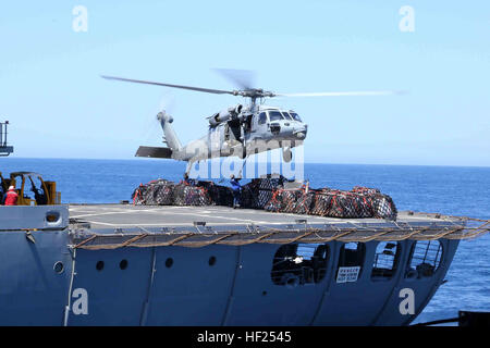 An MH-60S Knighthawk with Helicopter Sea Combat Squadron 23 (HSC-23) lifts cargo from the USNS Yukon (T-AO-202) to be transported to the USS Makin Island as part of a re-supply during Composite Training Unit Exercise (COMPTUEX) off the coast of San Diego, May 12, 2014. The 11th MEU and Amphibious Squadron 5 team conduct COMPTUEX to hone mission essential tasks, execute specified MEU and ARG operations, and establish the foundation for a cohesive war fighting team for future exercises and operations. (U.S. Marine Corps photo by Lance Cpl. Laura Y. Raga/RELEASED) USS Makin Island conducts re-sup Stock Photo