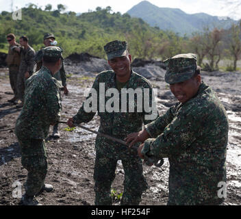 Philippine Marines pull a winch in and attach it to a bulldozer during a training event May 12, 2014 in Crow Valley, Philippines during Balikatan 2014. The training was part of the culminating event between the logistics combat element of U.S. Marine Forces Balikatan and the Philippine Marines. Balikatan is an annual training exercise that strengthens the interoperability between the Armed Forces of the Philippines and U.S. military and their commitment to regional security and stability, humanitarian assistance and disaster relief. The Philippine Marines are with Motor Transport and Maintenan Stock Photo