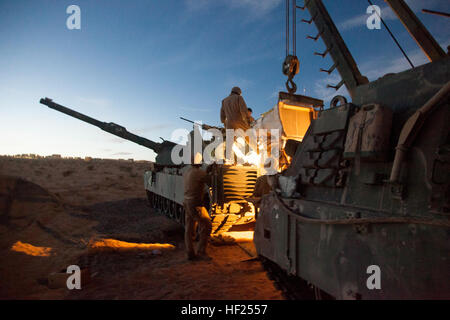 United States Marines assigned to Delta Company, 1st Tank Battalion, 1st Marine Division replace the engine of an M1A1 Abrams tank after repairs were completed during Desert Scimitar, May 12, 2014 aboard Marine Corps Air Ground Combat Center, Twentynine Palms, California. Desert Scimitar 2014 was a 1st Marine Division exercise held to test and refine its command and control capabilities by acting as the headquarters element for a forward-deployed Marine Expeditionary Force simultaneously offering units the opportunity to hone their conventional war fighting skills. (U.S. Marine Corps photo by  Stock Photo