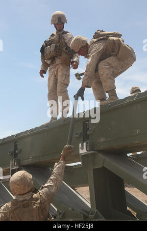 U.S. Marines with Bridge Company, 7th Engineer Support Battalion, 1st Marine Logistics Group, assemble a Medium Girder Bridge to enable Marines of 2nd Battalion, 7th Marine Regiment to reach their objective during Desert Scimitar aboard Marine Air Ground Combat Center Twentynine Palms, Calif., May 16, 2014. The distinct ability of the Marine Corps to gain access to critical areas anywhere in the world through air, ground and maritime capabilities enables us to aid our nation in efforts to resolve conflict, conduct humanitarian assistance or engage our nation's enemies in remote, austere enviro Stock Photo