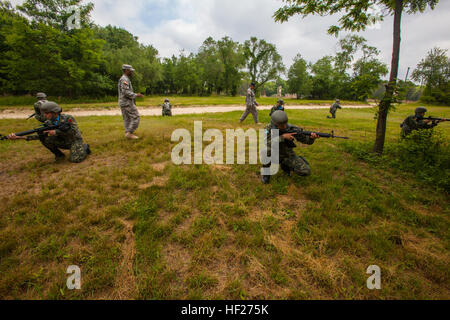 New Jersey Army National Guard drill instructors Staff Sgt. David R. Crenshaw, standing left, and Sgt. 1st Class Harry R. Martinez, standing right, observe members of the Albanian Officer Candidate Class 001 as they take up a defensive position during improvised explosive device training at Joint Base McGuire-Dix-Lakehurst, N.J., June 4, 2014. Albania is the first State Partnership Program country to send its officer candidates to the United States to attend an Officer Candidate School (OCS) program. The 12-week NJARNG OCS program is modeled after the active-duty program at Fort Benning, Ga.,  Stock Photo