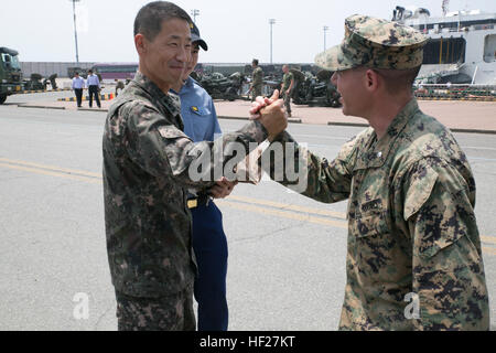 U.S. Marine Lt. Col. Matthew J. Gorboty, right, shakes hands with a Republic of Korea Marine at Pyeongtaek Port, South Korea, June 9 after arriving for Korean Marine Exchange Program 14-7. KMEP strengthens relationships between ROK and U.S. Marines by providing unique opportunities to train together. Gorboty is a Westfield, New Jersey, native and field artillery officer with 12th Marine Regiment, 3rd Marine Division, III Marine Expeditionary, Marine Corps Installations Pacific. (U.S. Marine Corps photo by Lance Cpl. Thor J. Larson/Released) US Marine offload signals start of Korean Marine Exch Stock Photo