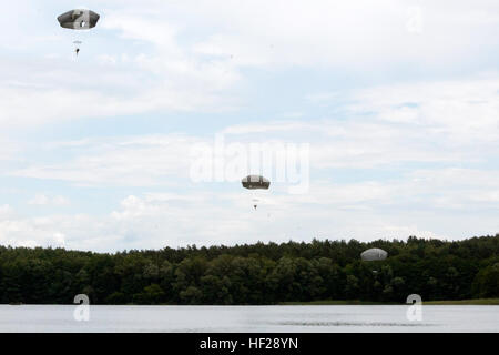 Spc. Aaron Festinger, Cpt. Stephen Stacey and Sgt. Steven Jeffries, members of 1st Battalion, 503rd Airborne Infantry, 173rd Airborne Brigade, descend towards a lake during a water entry training exercise June 24, at a Polish military training camp outside of Drawsko-Pomorskie, Poland. The 'Sky Soldiers' are in Poland at the request of the host nation to participate in combined training exercises with the 3rd Battalion, Princess Patricia's Canadian Light Infantry and Poland's 6th Airborne Brigade. (U.S. Army photo by Sgt. Eric McDonough, Oklahoma Army National Guard/Released) Paratroopers cond Stock Photo