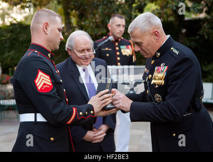 The Evening Parade host, the Assistant Commandant of the Marine Corps, Gen. John M. Paxton, Jr., right, presents a Navy Distinguished Public Service Award to the parade guest of honor, Michigan Sen. Carl M. Levin, center, during the parade reception at the Home of the Commandants in Washington, D.C., July 25, 2014. The Evening Parades are held every Friday night during the summer months. (U.S. Marines Corps photo by Cpl. Tia Dufour/Released) Evening Parade 140725-M-KS211-026 Stock Photo