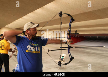 A Marine sights in during archery practice for the 2014 Warrior Games on Sept. 20 in Colorado Springs, Colorado. The team, including active duty and veteran wounded, ill, and injured Marines, trains at high altitude to build cohesion, improve skills, and prepare for competition with support from the Wounded Warrior Regiment. Stock Photo