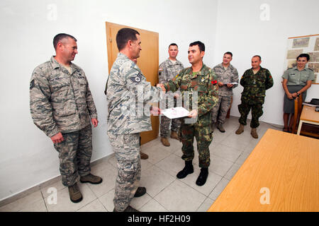 Tech. Sgt. John Hurley, left, watches as Staff Sgt. Joe Coates, both members of the 177th Fighter Wing Explosive Ordnance Disposal team, New Jersey Air National Guard, presents Albanian Army Capt. Klodian Nuredini a certificate of completion at Peze Helmes, Republic of Albania, Sept. 26, 2014. In September 2014, the 177th EOD team trained Albanian Army EOD soldiers to become level 1 EOD trainers. New Jersey National Guard Airmen and Soldiers have been training their Albanian counterparts for more than 20 years as part of the State Partnership Program between the state of New Jersey and the Rep Stock Photo